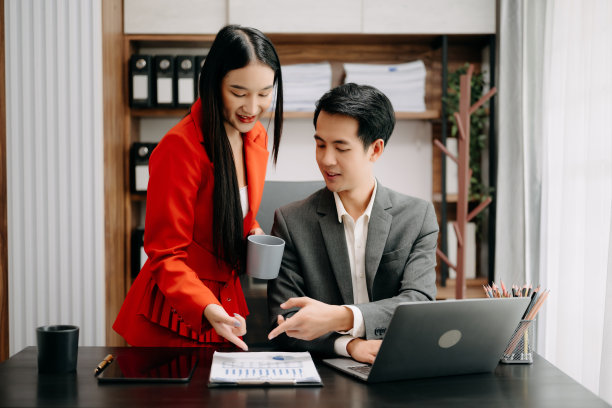 亚洲商务同事商务演示和解释，并使用笔记本电脑和平板电脑。团队合作，金融营销团队，坐在办公室里。图片下载