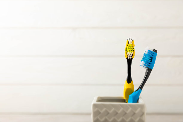 一组彩色牙刷的特写镜头，在一个灰色背景的玻璃杯里。牙科的概念。口腔护理。浴室化妆产品的概念。侧视图，复制空间。口腔卫生图片下载