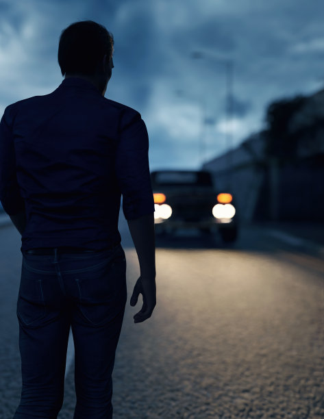 在暴风雨的天空下，一名男子走向一辆车灯亮着的汽车。3 d渲染。图片下载