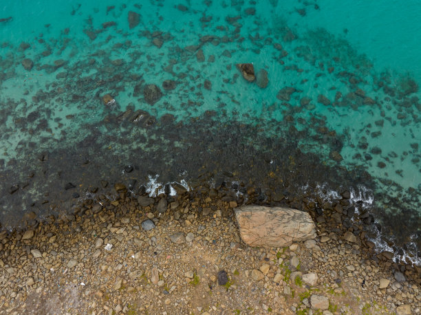 抽象的空中照片卵石海滩旁边的蓝色大海与海浪，Con岛，Con Son岛，巴里亚头省图片下载