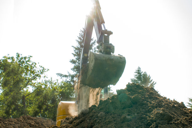 土从一个迷你挖掘机的桶里掉下来图片下载