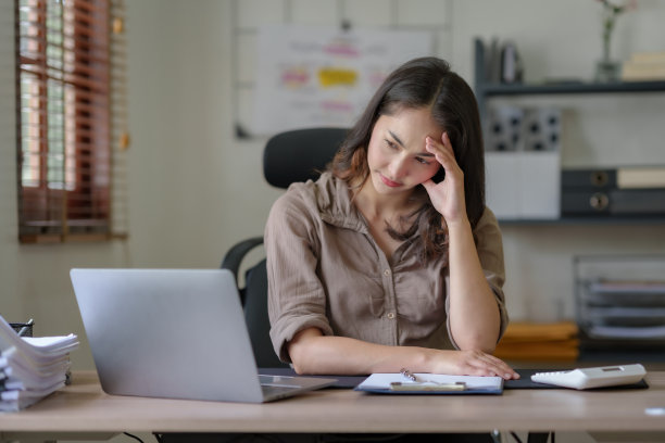 在漫长的一天工作后，亚洲女商人坐在办公室里感到疲惫、压力或筋疲力尽。图片下载