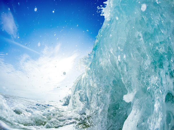 海浪在海滩上的崩溃-泡沫的蓝色海浪粉碎在高峰的特写镜头。图片下载