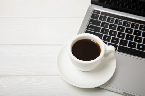 办公桌的俯视图。工作区，笔记本电脑，眼镜和咖啡杯在纹理黑色背景。平的。图片下载