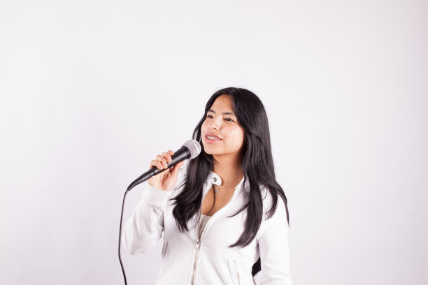 年轻女子拿着麦克风唱歌图片下载