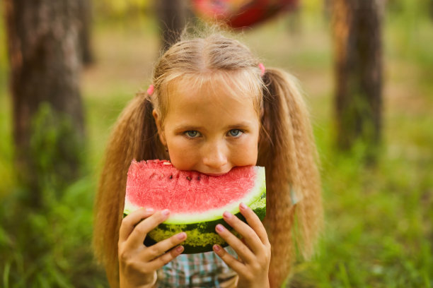 可爱的女孩在森林公园吃西瓜图片下载