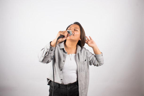 拿着麦克风热情歌唱的拉丁女子。图片下载