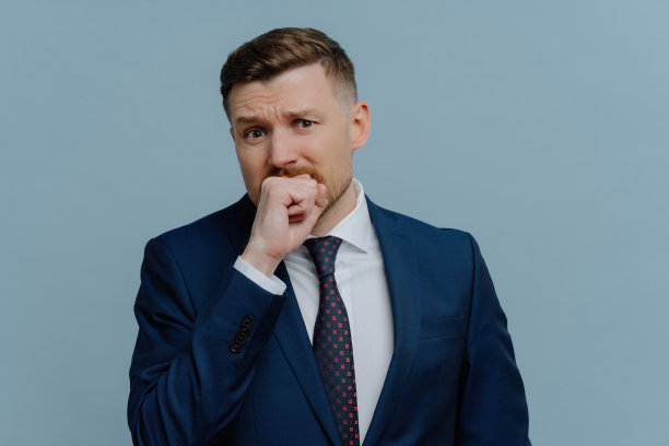 穿着西装的紧张商人，情绪化地咬着拳头，背景是浅蓝色。业务问题和失败图片下载