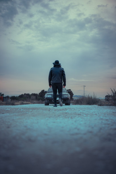 电影场景:一辆车里有一个戴帽子穿夹克的男人图片下载