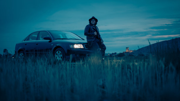 电影场景:一辆车里有一个戴帽子穿夹克的男人图片下载