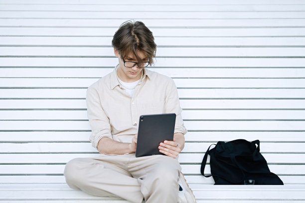 年轻人坐在长凳上使用笔记本电脑图片下载