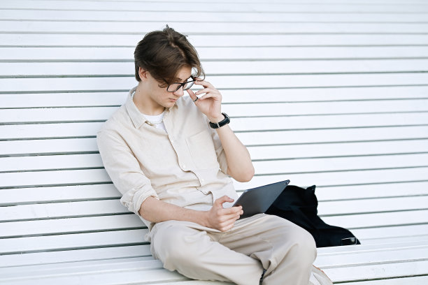 年轻人坐在长凳上使用笔记本电脑图片下载