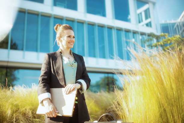 商务中心附近微笑的现代女员工图片下载