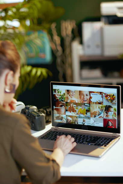 从摄影师身后看到的女人拿着笔记本电脑在看照片图片下载