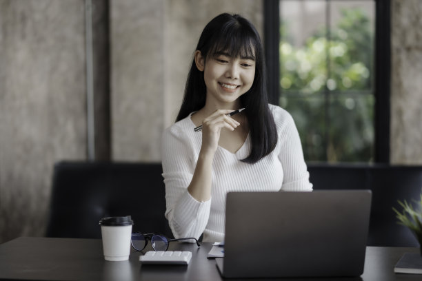 美丽的亚洲女商人正在考虑新的想法，她的工作与明亮和快乐的脸。图片下载