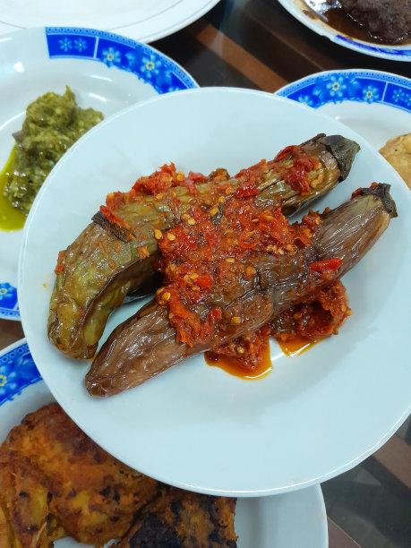 印尼西苏门答腊岛食品- Nasi Padang - terong balado或茄子配红辣椒参巴。将茄子或茄子浸泡在盐水中，然后油炸，然后将红辣椒，青葱和西红柿混合在一起形成辛辣的参巴。图片下载