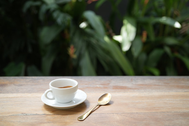 白色的咖啡杯放在木桌上，笔记本放在木桌上图片下载