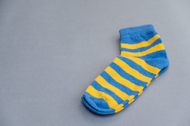 蓝黄相间的袜子衬着灰色的背景。一双鲜艳的条纹短袜图片下载