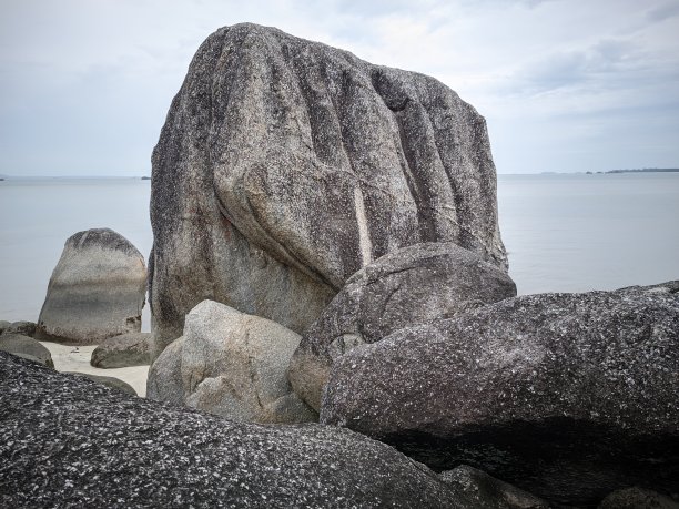 非常大而高的珊瑚岩在普达海滩的边缘-邦加岛图片下载