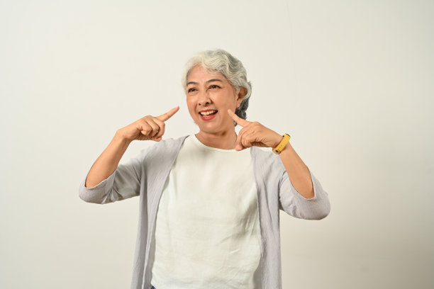 漂亮的白发老妇人在白色背景上微笑着摆姿势。图片下载