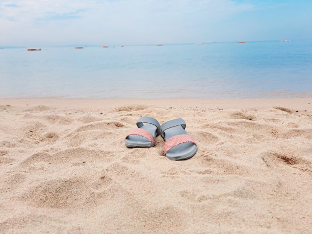 沙滩上女人的鞋子。图片下载