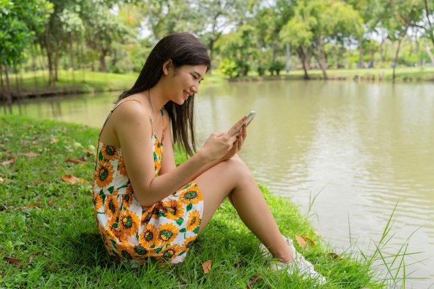 年轻的亚洲女士chill放松和视频电话在公园图片下载