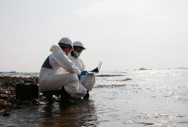 穿着防护服的科学家或生物学家分析流入大海的废水图片下载