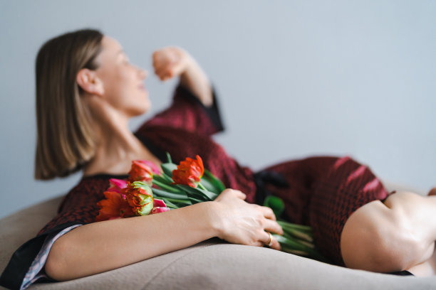 年轻女子享受花在家里放松的软豆袋图片下载