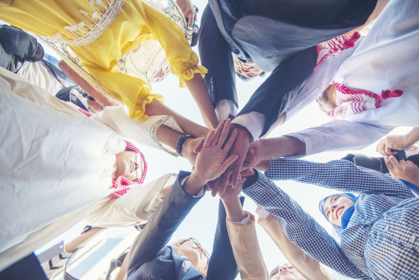 快乐多元多民族伙伴携手共进。多种族微笑人群的团队合作，携手共进。多元化的人加入授权伙伴关系团队志愿者联系图片下载