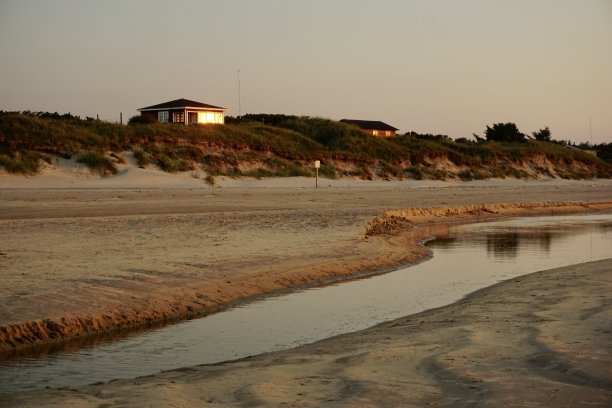 夏天日落时沙丘上的丹麦房子。日落时丹麦的海滨别墅。夏天的丹麦沙丘。丹麦的海滩和沙丘。日落时分的丹麦Kjul海滩。图片下载