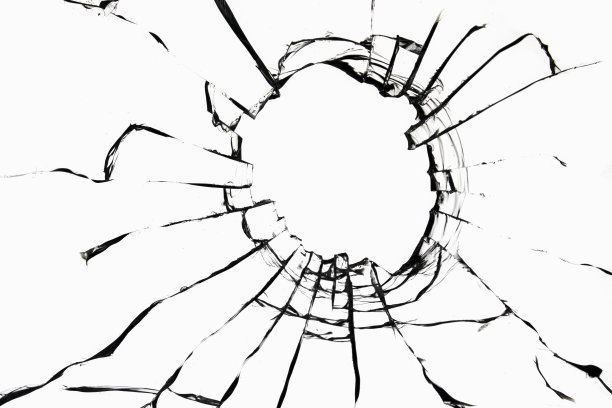 在白色背景上的玻璃上有一个洞的裂缝纹理。破窗效应。用于设计的照片。图片下载