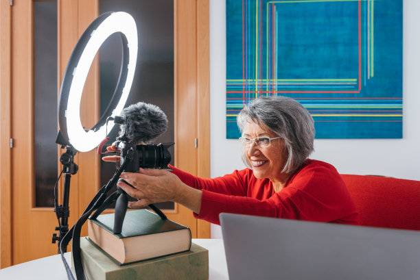 微笑的女人在配置摄像头。图片下载