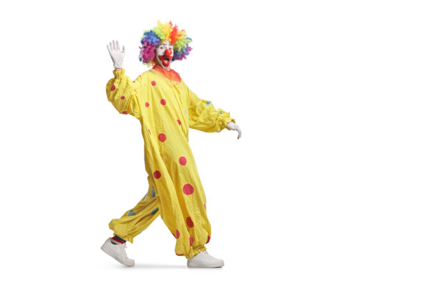 一个穿着黄色服装的小丑走路和挥手的全长镜头图片下载