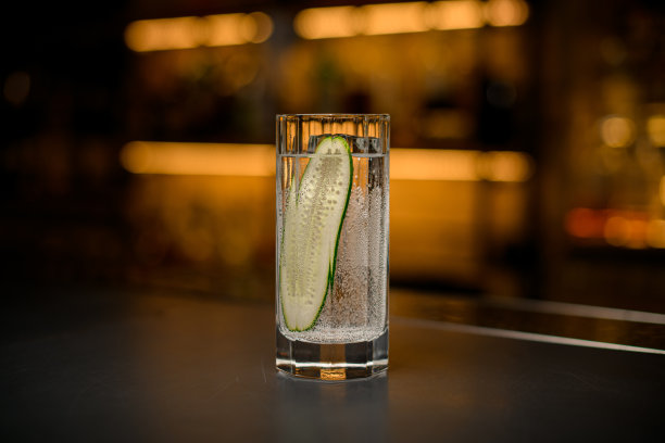前视图面玻璃冷碳酸饮料与一片新鲜黄瓜图片下载