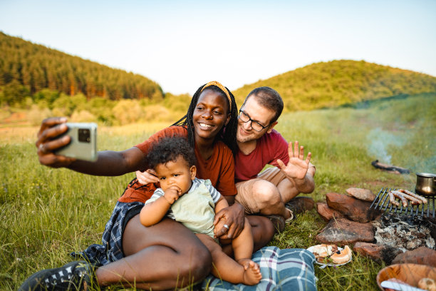 幸福的家庭和小男孩在草地上烧烤野餐图片下载