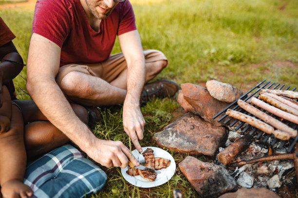 幸福的家庭和小男孩在草地上烧烤野餐图片下载