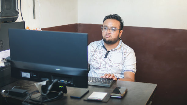 在办公室里摆弄电脑的印度年轻商人。图片下载