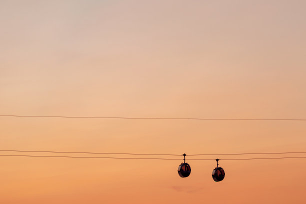 橙色落日的天空映衬着索道的剪影图片下载