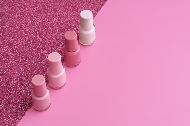 时髦的设计模板与指甲油玻璃瓶在粉红色和闪闪发光的背景。图片下载