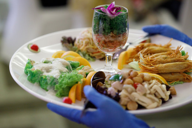 在餐馆里，面目全非的服务员端着一盘中餐，准备为客人服务图片下载