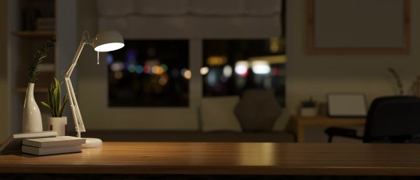 夜间现代家庭办公室中带有复制空间的木制桌面的特写图像。图片下载