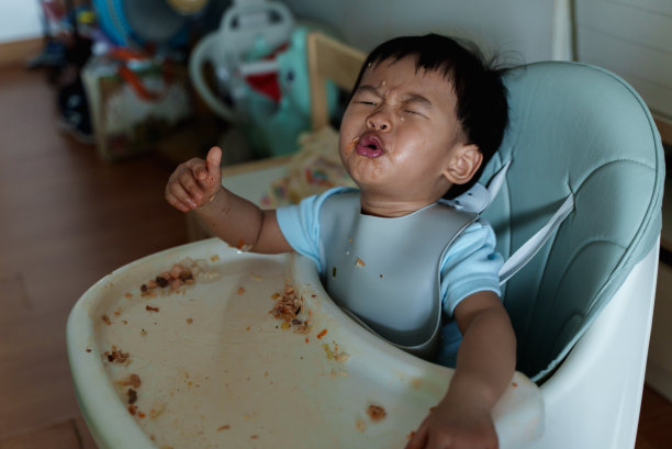 凌乱的宝宝用手自己喂奶。婴儿主导断奶(BLW)概念图片下载
