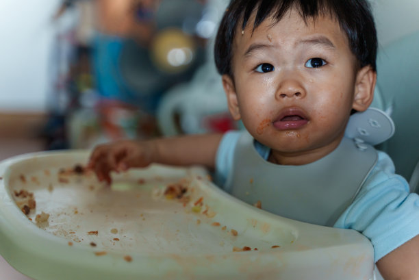 凌乱的宝宝用手自己喂奶。婴儿主导断奶(BLW)概念图片下载