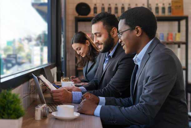 年轻的多种族商务人士在玻璃窗旁的咖啡厅随意工作图片下载