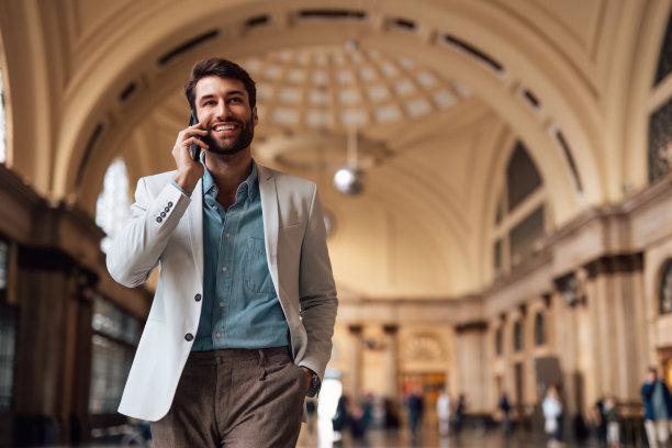 站在交通车站的现代英俊商人。图片下载