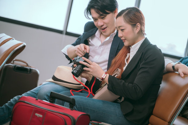 一对情侣在大厅里等飞机时摆姿势拍照。图片下载