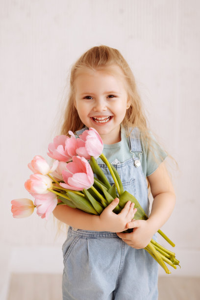 一个金发小女孩拿着一束春花的肖像图片下载