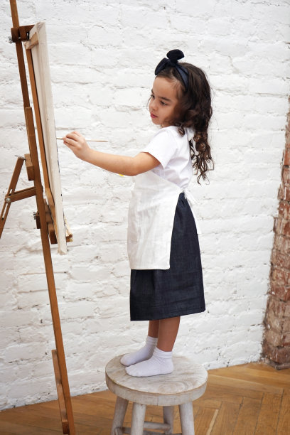 才华横溢的女艺术家用画笔在画架上作画。艺术学校工作坊。垂直方向。图片下载