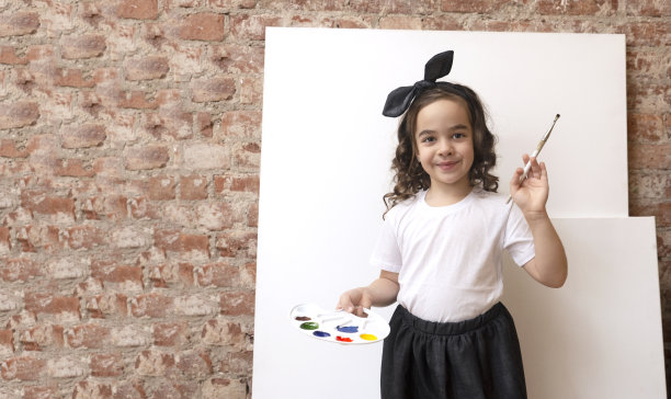 才华横溢的女孩艺术家与调色板的颜色和画笔。艺术学校工作坊。副本的空间。图片下载