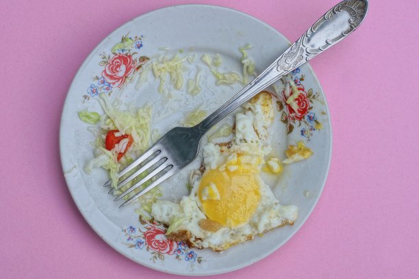 一个白色的盘子里放着一块吃了一半的黄色炒鸡蛋图片下载